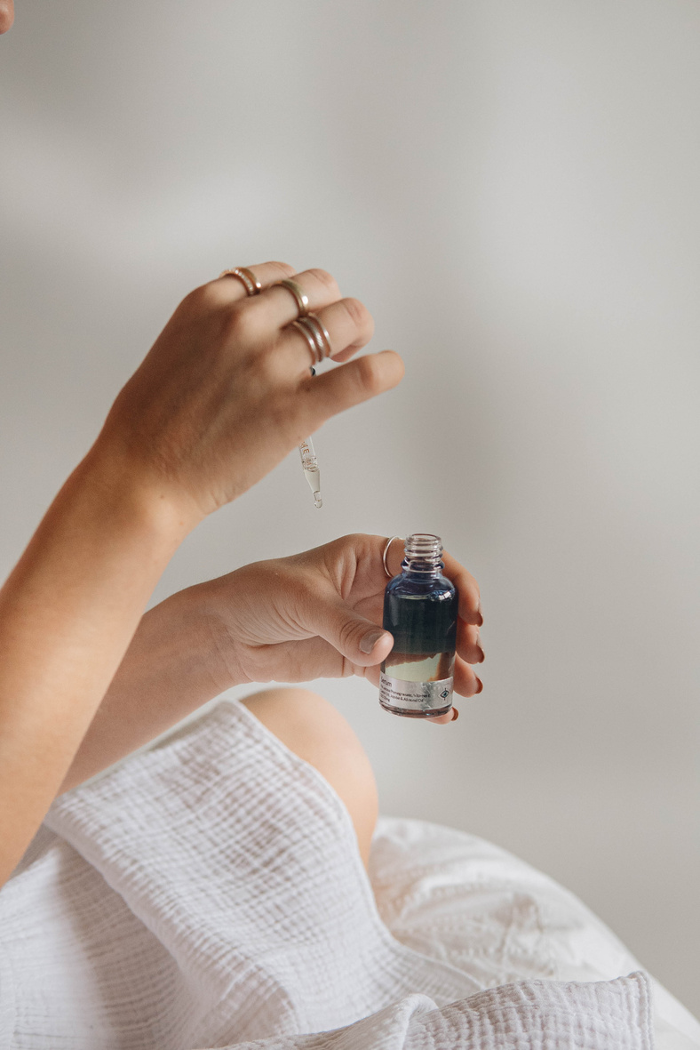 Person Holding Black Glass Bottle